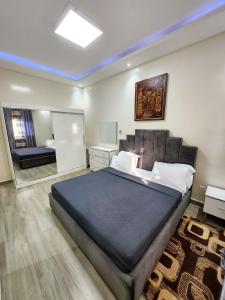a bedroom with a large bed and a mirror at F3 Appartement Point E Dakar in Dakar