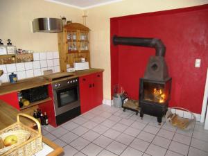a kitchen with a stove in a red wall at Sandburg in Zempin +6 photos