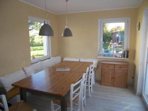 a living room with a wooden table and white chairs at Sandburg in Zempin