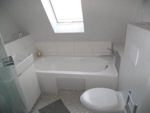 a bathroom with a white tub and a toilet at Sandburg in Zempin