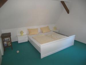 a white bed with two pillows on it in a room at Sandburg in Zempin