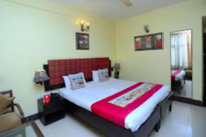 1 dormitorio con 1 cama grande y cabecero rojo en Goroomgo D2 Holiday inn Near Sea Beach, en Puri
