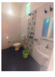 uma casa de banho com um lavatório, um WC e um lavatório. em Goroomgo D2 Holiday inn Near Sea Beach em Puri