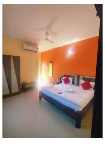 duże łóżko w pokoju z pomarańczową ścianą w obiekcie Goroomgo D2 Holiday inn Near Sea Beach w mieście Puri