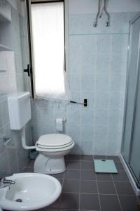 レウカにあるA Casa di Doralucia - Comfort a Santa Maria di Leucaのバスルーム(トイレ、洗面台付)、窓が備わります。