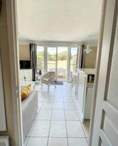 a living room with a couch and a table at "MOULIN VERT RIVAGE" Maison, 6 personnes, au coeur du golf, village vacances, accès piscines gratuit in Talmont