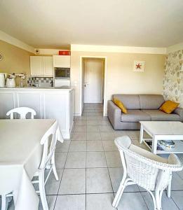 a living room with a couch and a table at "MOULIN VERT RIVAGE" Maison, 6 personnes, au coeur du golf, village vacances, accès piscines gratuit in Talmont +12 photos