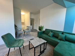 a living room with a green couch and a table at Elegant 2+1 BR Apt at Vienna's Vibrant 3. District in Vienna