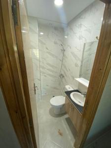 La salle de bains est pourvue de toilettes, d'un lavabo et d'un miroir. dans l'établissement Holikeys - Fès - 3 Ch - Lot Brdai 003, à Fès