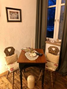 a table with a candle and two chairs in a room at Jägerwohnung in Süderholz