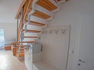 - un escalier dans une maison dotée de murs blancs et de parquet dans l'établissement Apartment Šmon, à Kranjska Gora