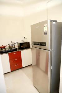 a kitchen with a stainless steel refrigerator and a microwave at Fortune Home Service Apartment 3Bhk,E-28, Saket 2B in New Delhi