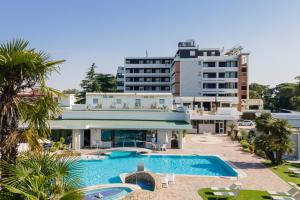 Hotel Terme Delle Nazioni في مونتيجروتو تيرمي: فندق فيه مسبح امام مبنى