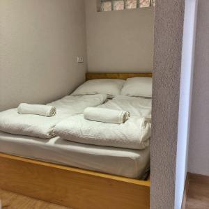 Duas camas sentadas numa plataforma de madeira num quarto em KuPihenő Apartman Kunfehértó em Kunfehértó