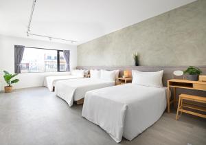 una camera d'albergo con due letti e una finestra di Donggang Jingdi B&B a Donggang