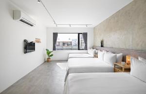szereg łóżek w pokoju z oknem w obiekcie Donggang Jingdi B&B w mieście Donggang