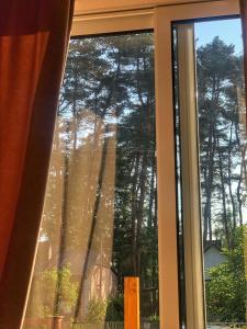 una ventana con vistas a un bosque de árboles en KuPihenő Apartman Kunfehértó, en Kunfehértó