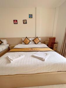 - une chambre avec 2 lits et des serviettes dans l'établissement Galaxy VangVieng Hotel, à Vang Vieng