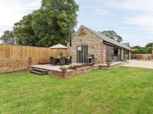 a stone house with a patio and a fence at The Cart Shed in Witton Gilbert