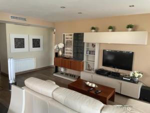a living room with a white couch and a flat screen tv at PISO DE LUJO EN TORRENOSTRA in Torreblanca