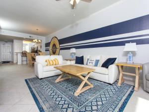 ナバーにあるThe Pearl of Navarre #1102 - Beach Life Paradiseのリビングルーム(白いソファ2台、木製テーブル付)