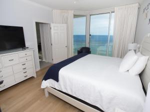 ナバーにあるThe Pearl of Navarre #1102 - Beach Life Paradiseの白いベッドルーム(ベッド1台、テレビ付) +34枚の写真