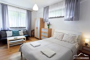 Un dormitorio pequeño con una cama y un sofá. en Zielone Wzgórze, en Wisła