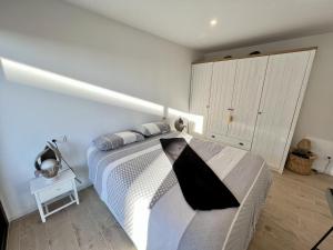1 dormitorio con 1 cama con manta blanca y negra en IBR - Rhodes 23 en Rosas