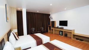 um quarto de hotel com duas camas e uma televisão de ecrã plano em Khách sạn Lam Anh Ngoại Giao Đoàn Hà Nội em Hanói