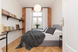 a bedroom with a bed and a brick wall at Warsaw Pruszków Park View Comfortable Apartments by Renters in Pruszków