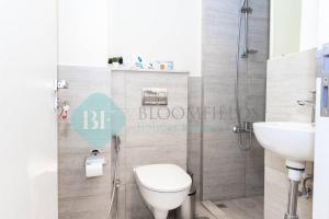 a bathroom with a toilet and a sink at Spectacular 2 Bedroom In Oasis in Al Qurayyah