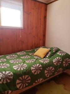 1 dormitorio con 1 cama con edredón verde y blanco en Linda, cómoda y acogedora casa para 6, en Pichidangui