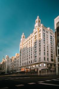 een groot wit gebouw aan de straatkant bij Apartamentos Soho Boutique Hoy No Me Puedo Levantar in Madrid