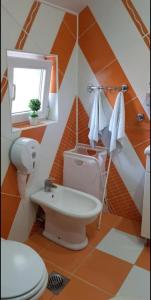 uma casa de banho laranja e branca com um WC e um lavatório em Lux Apartments With Pool Dex em Zemun Polje