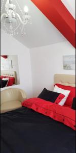 um quarto com uma cama vermelha e uma parede branca em Lux Apartments With Pool Dex em Zemun Polje