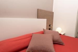 a bedroom with a red bed with two pillows at Zenit Hotel in Giulianova