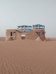 un edificio en medio del desierto en désert tours & Hôtel Titanic lac irik en Foum Zguid