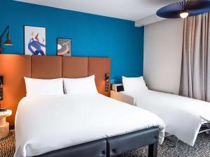 2 Betten in einem Zimmer mit blauen Wänden in der Unterkunft ibis La Baule Pornichet Plage in Pornichet