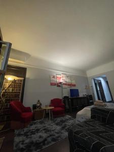 ein Wohnzimmer mit 2 roten Stühlen und einem Tisch in der Unterkunft Élysées vip in Paris