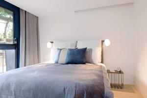 a bedroom with a bed with blue pillows and a window at Quiet and Peaceful House near Marble Arch in London