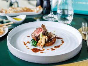 a white plate with food on a table at Sofitel Roma Villa Borghese in Rome