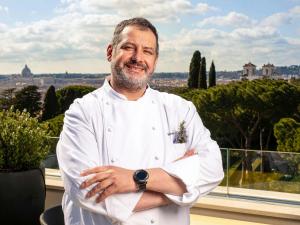 a chef standing on a balcony with his arms crossed at Sofitel Roma Villa Borghese in Rome