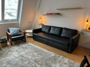 a living room with a black couch and a chair at Apartamento Astun in Astun 