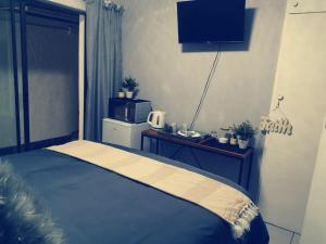 a bedroom with a bed and a table with a microwave at Be Our Guest Near OR TAMBO International Airport in Boksburg +4 photos