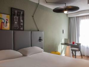 sypialnia z łóżkiem, stołem i oknem w obiekcie ibis Cannes Centre w Cannes