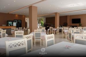 a dining room with white tables and white chairs at Hotel Marika in Golem