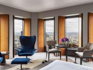 a room with chairs and a table and windows at Sofitel Melbourne On Collins in Melbourne