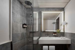 a bathroom with a sink and a shower at Avani Frankfurt City Hotel - previously NH Collection Frankfurt City in Frankfurt