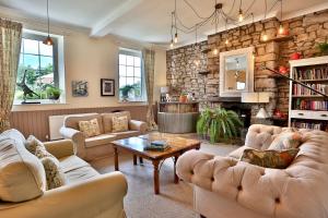 a living room with couches and a stone wall at Ty Croeso House in Llangattock