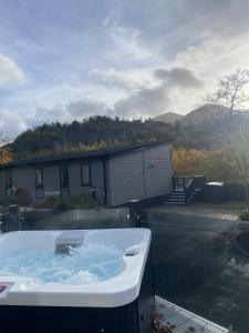 a bath tub sitting in the backyard of a house at SL06 - Idwal Lodge with Hot Tub in Bangor